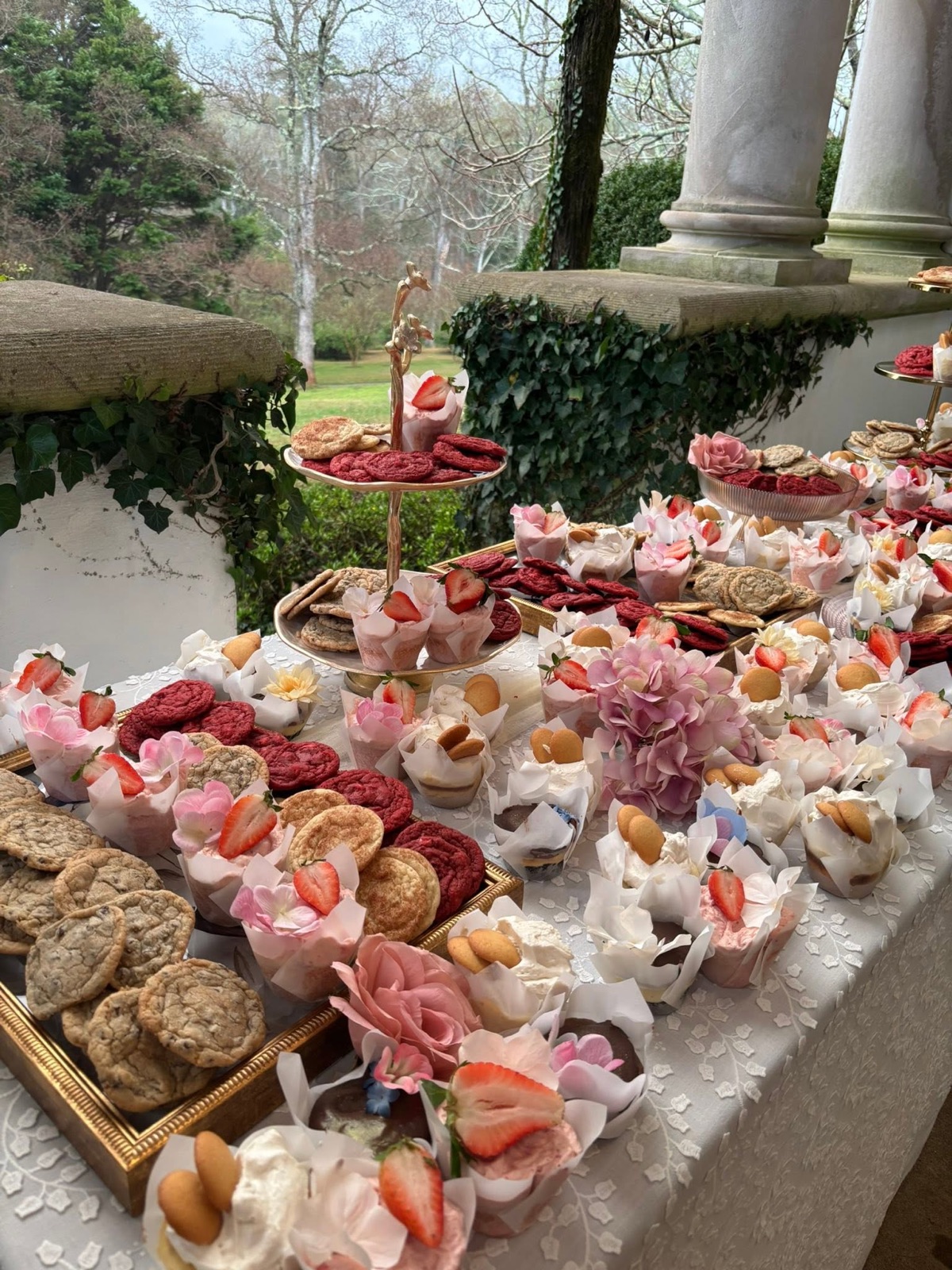 A Kimmy Cakes dessert spread laid out on a long table with cakes, cookies and dessert cups