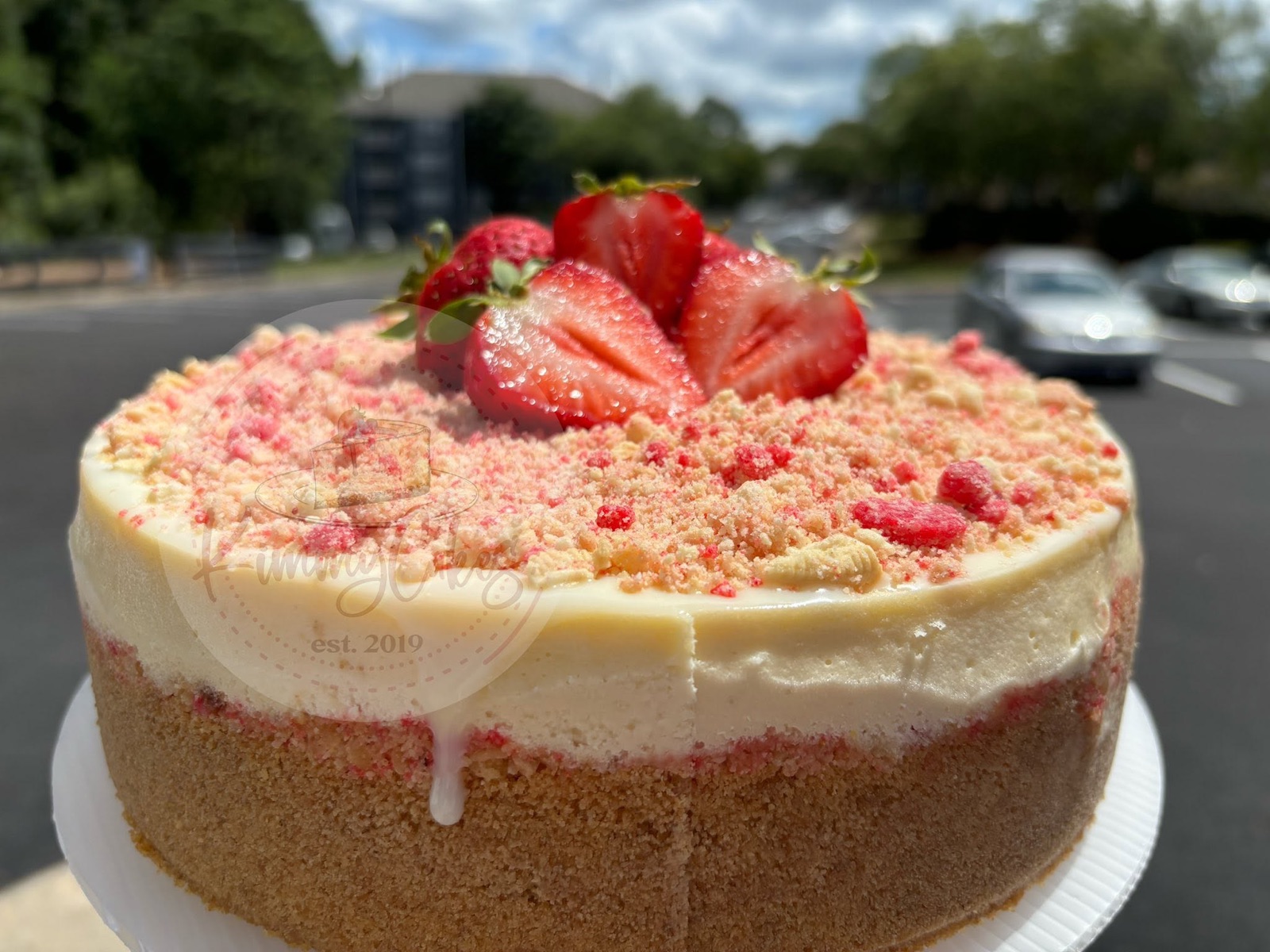 A whole strawberry cheesecake finished with fresh strawberries