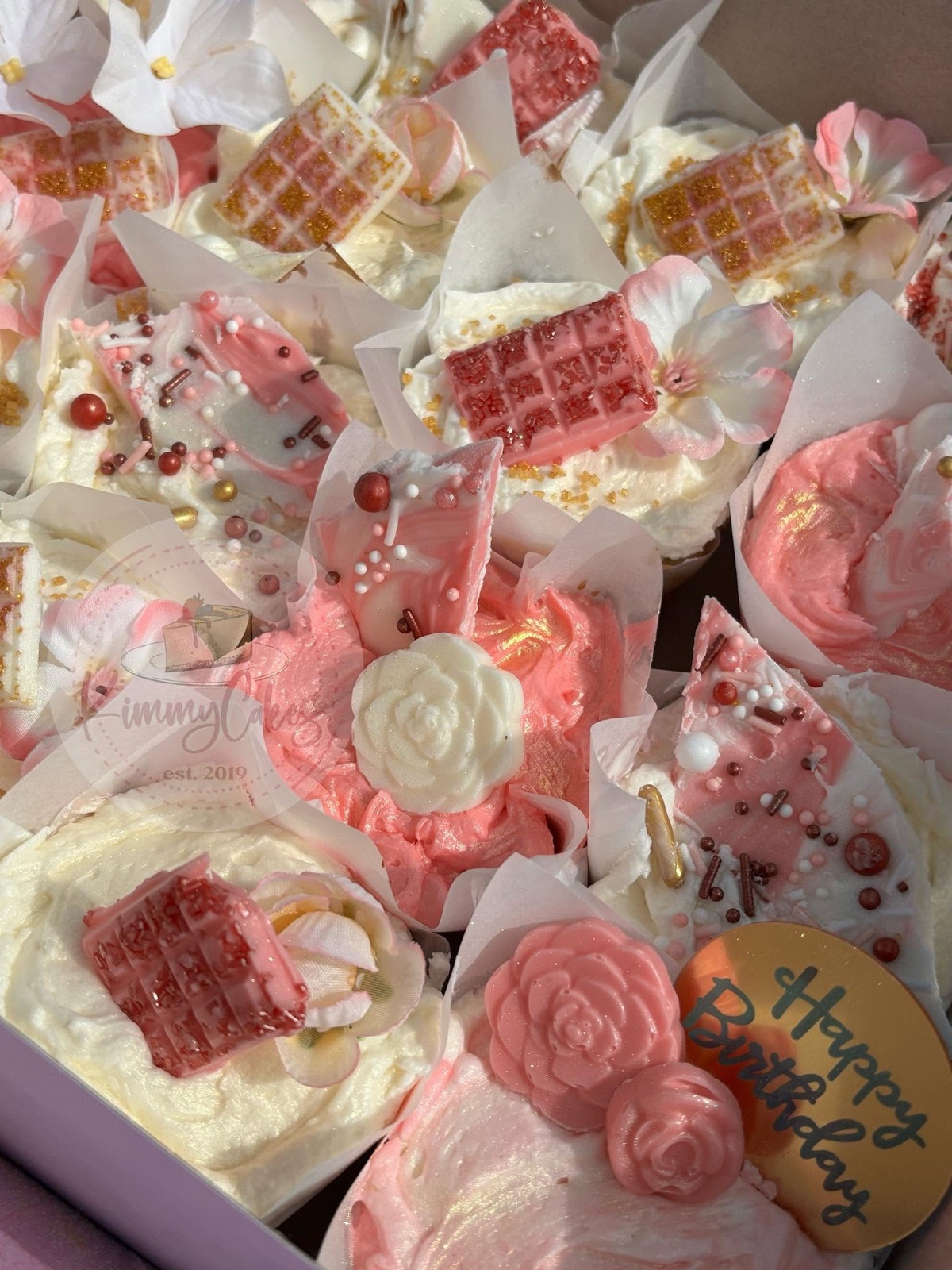 Cupcakes piped in soft pink with sugar roses