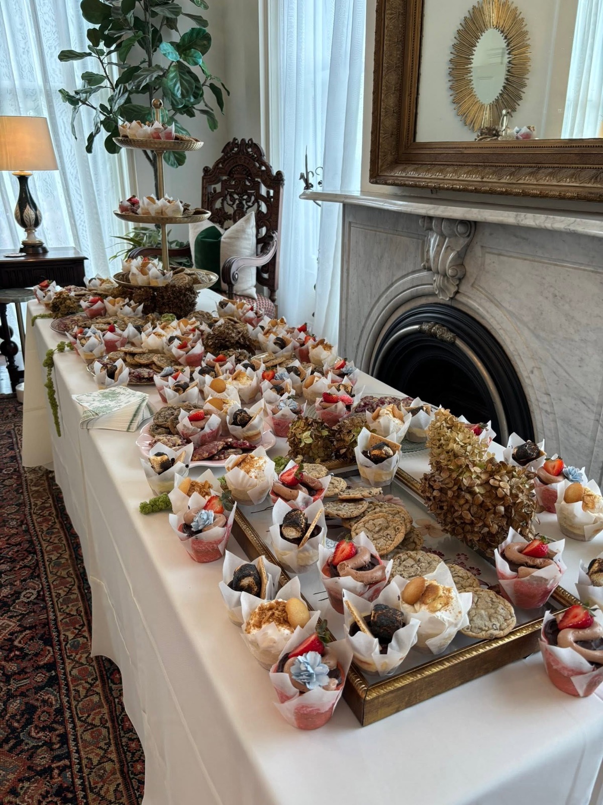 A long dessert table set end to end with Kimmy Cakes cheesecake cups, cookies and cakes