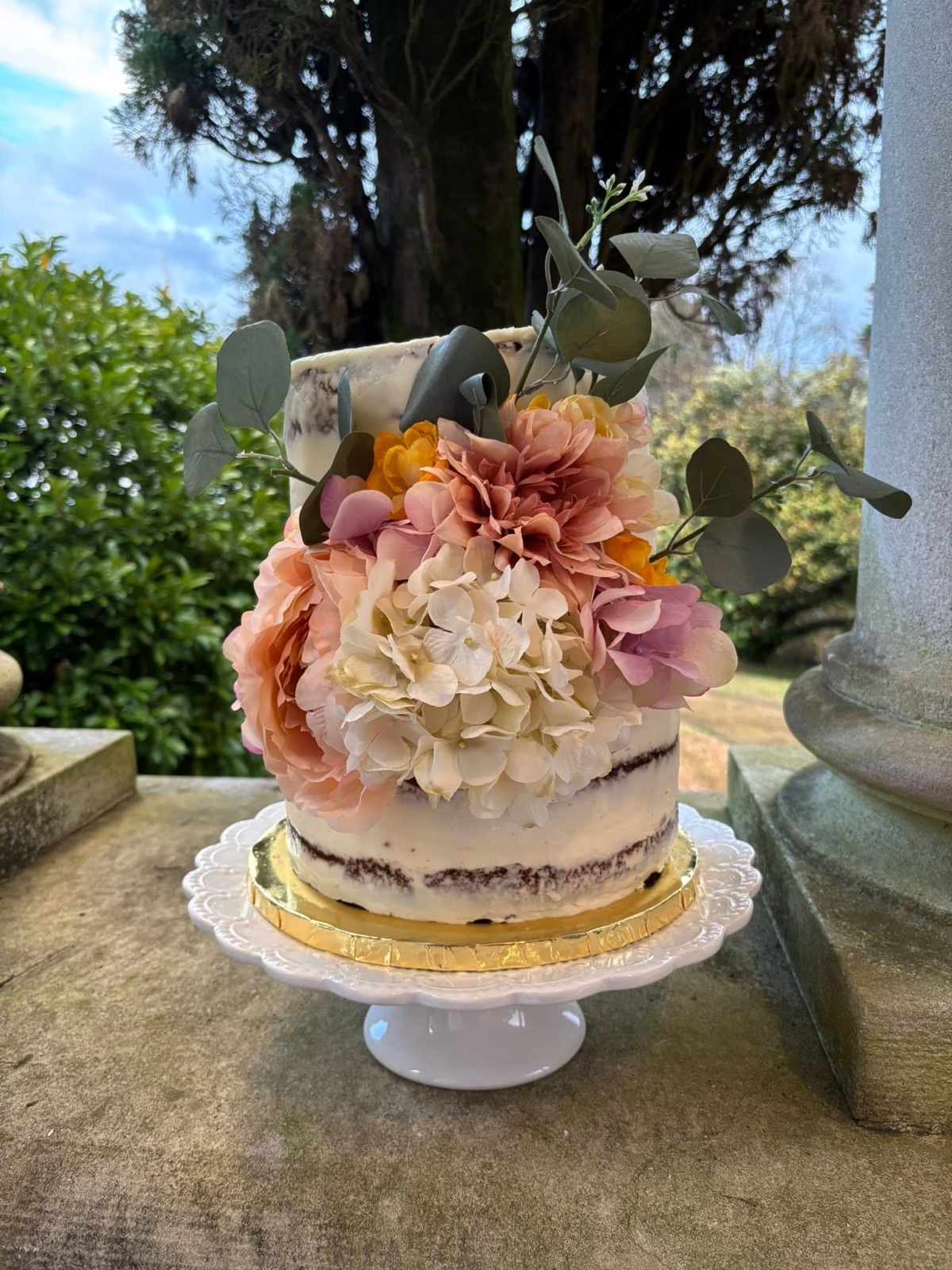 Tiered wedding cake dressed with fresh flowers